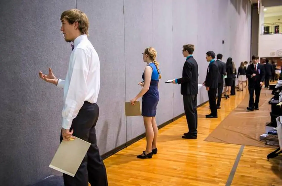 A student rehearsing a speech in a school hallway at a tournament
